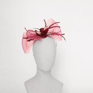 Tocado lazo fucsia con plumas burdeos